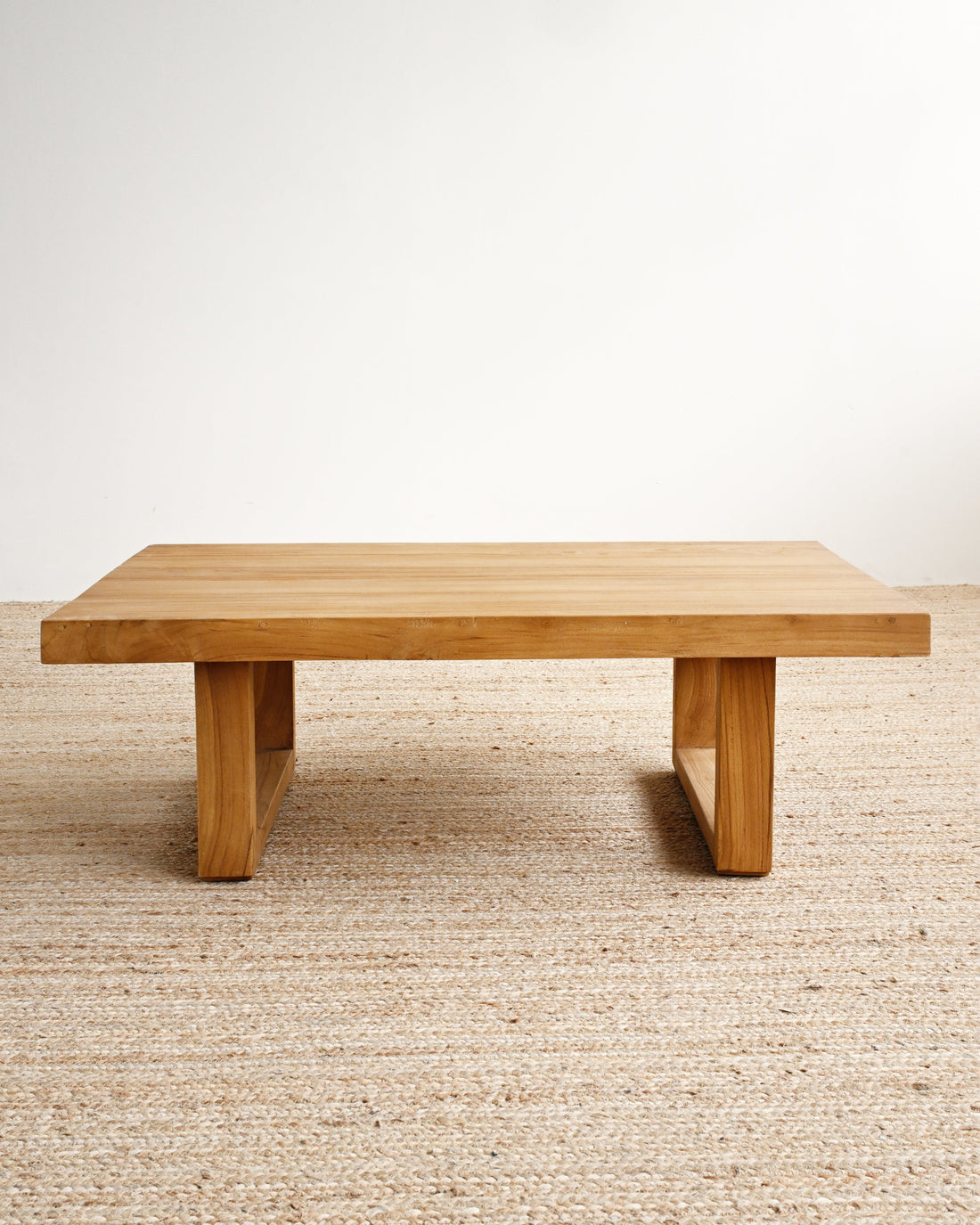 Wooden table on a beige carpet with a white wall background