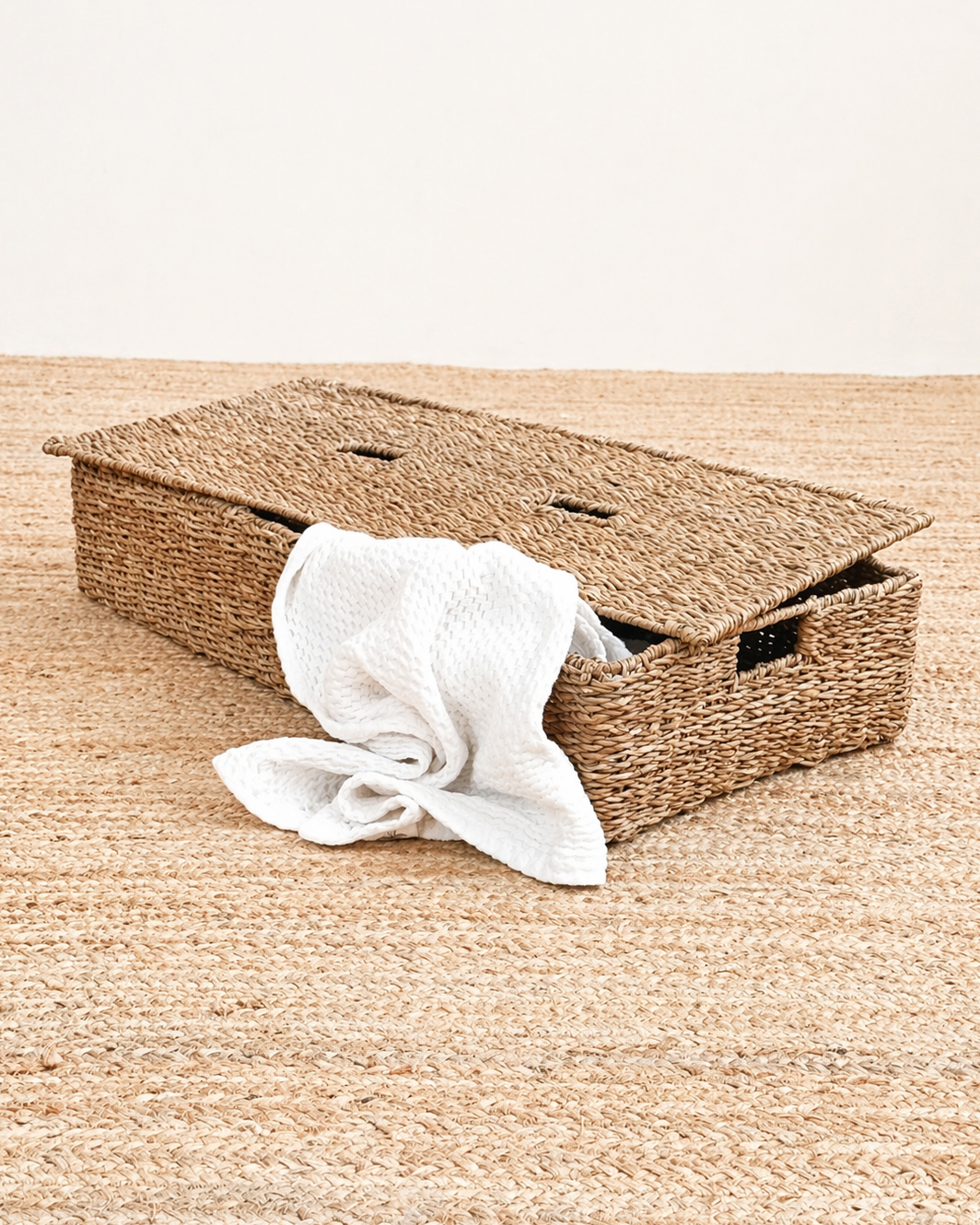 Woven storage basket with a white cloth on a wooden surface