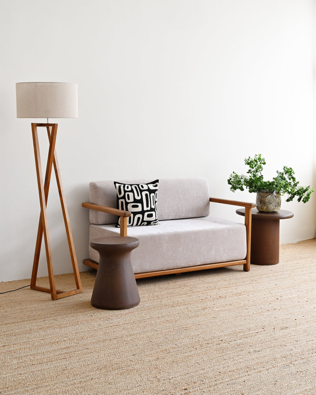 Modern living room with a gray sofa, wooden floor lamp, and side table.