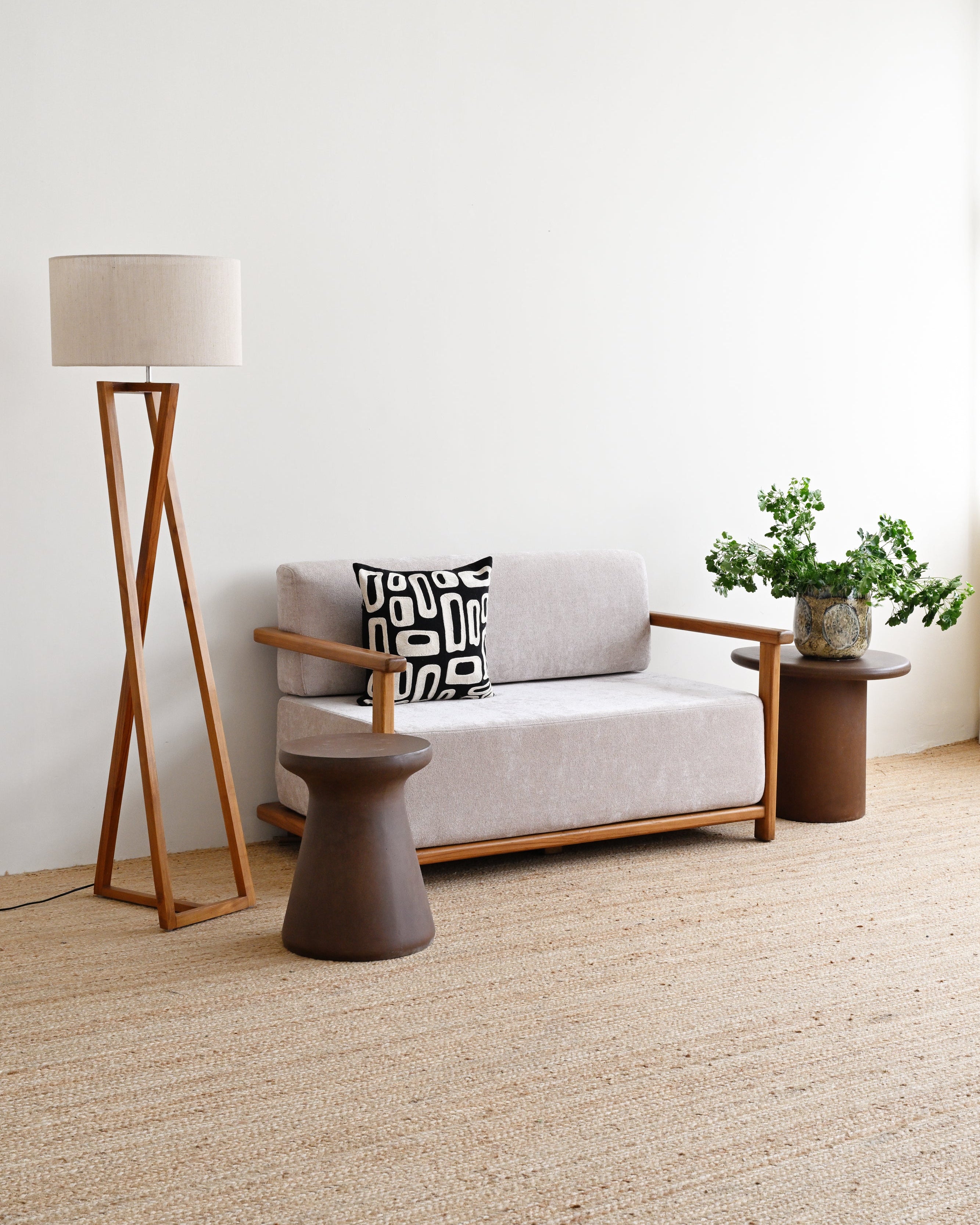 Modern living room with a gray sofa, wooden floor lamp, and side table.