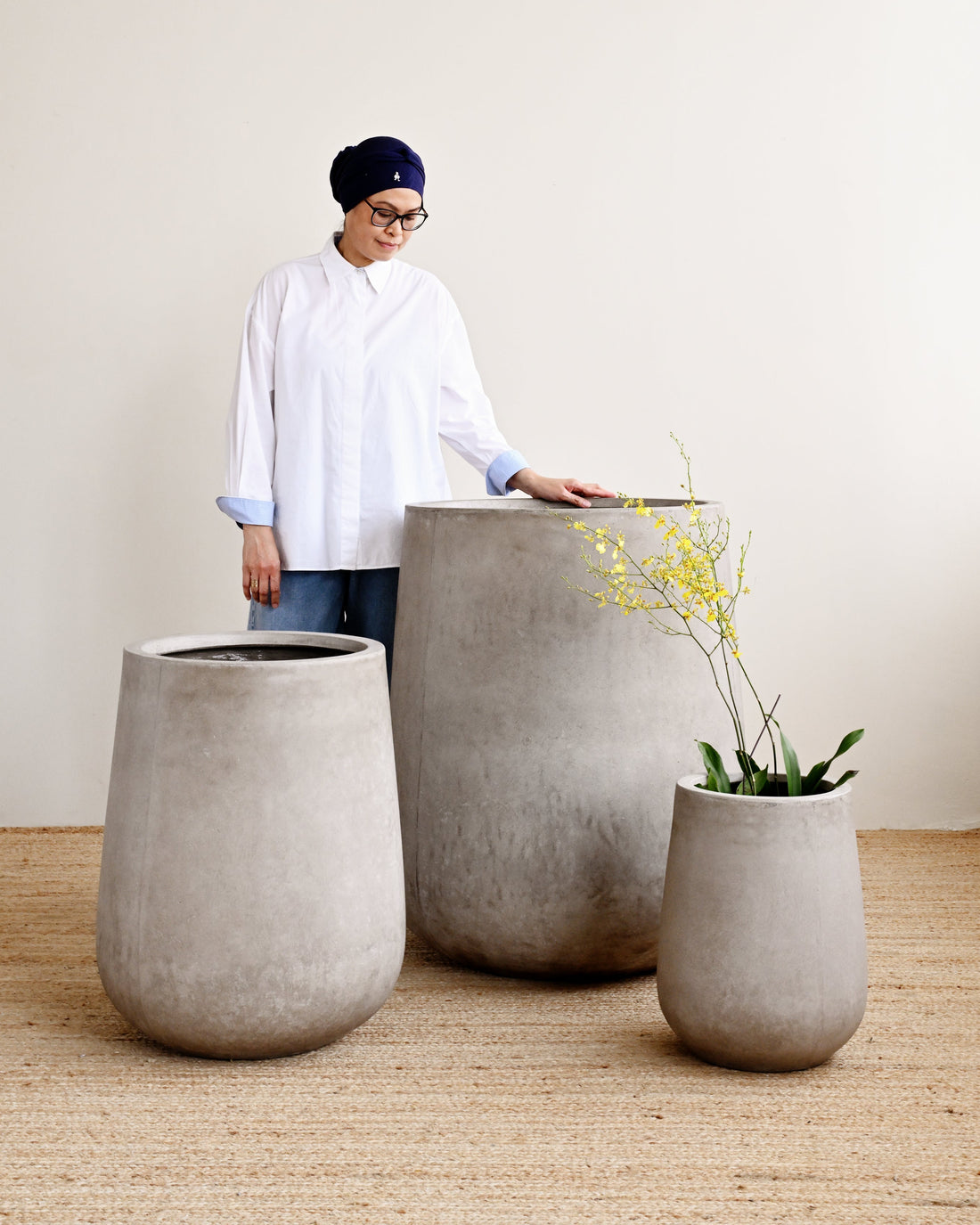 Person interacting with large concrete planters indoors
