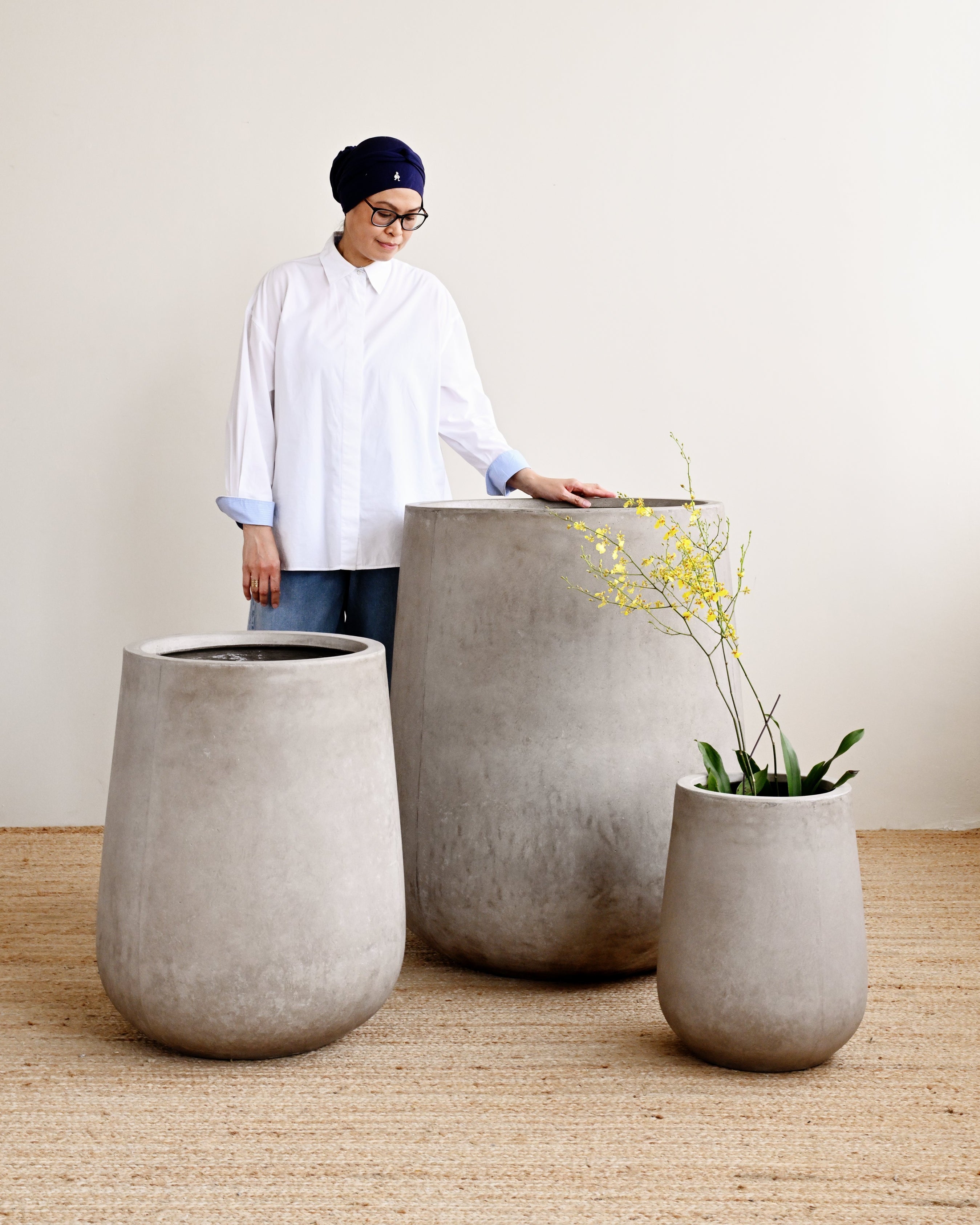 Person interacting with large concrete planters indoors