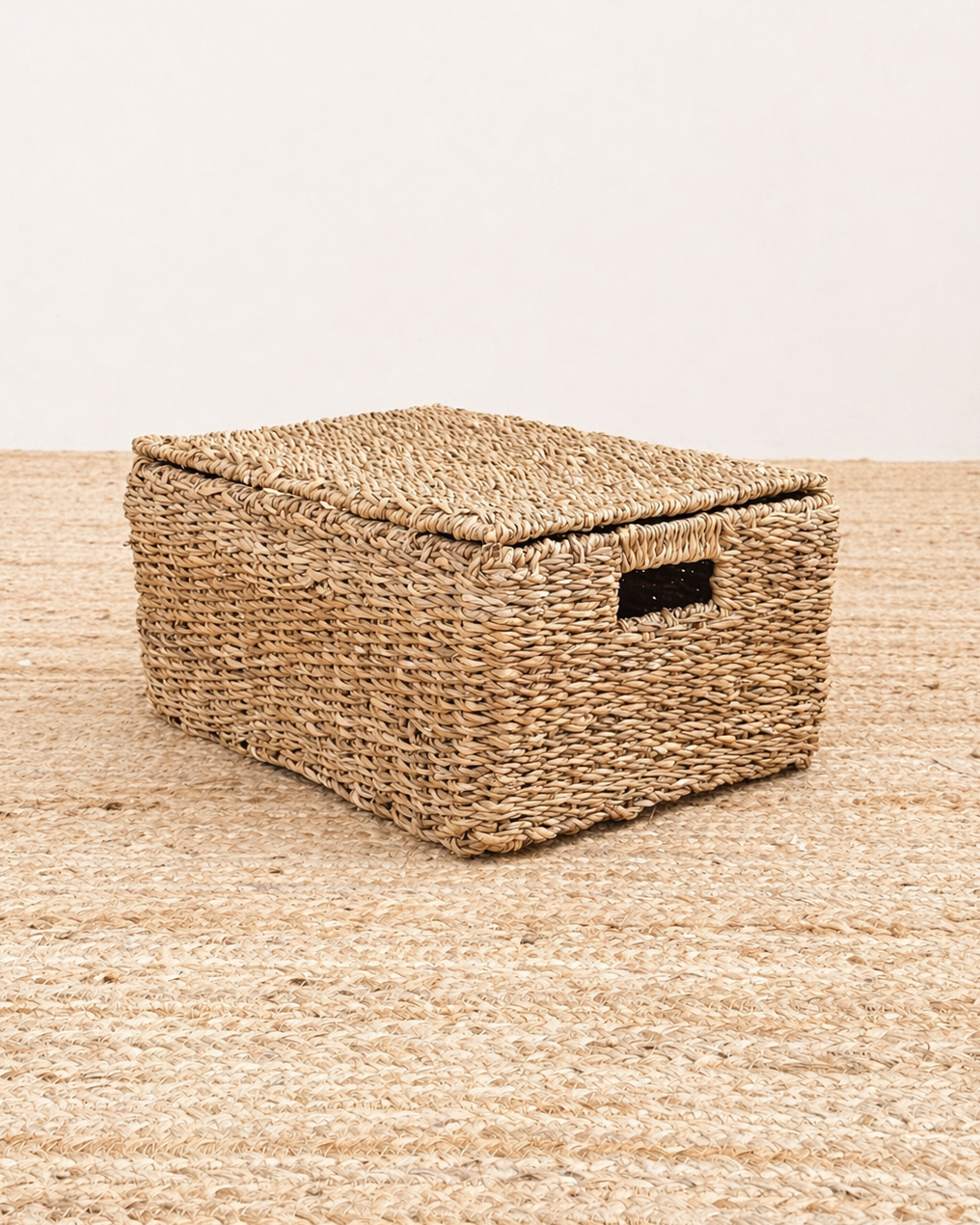 Woven storage basket with a lid on a matching woven surface