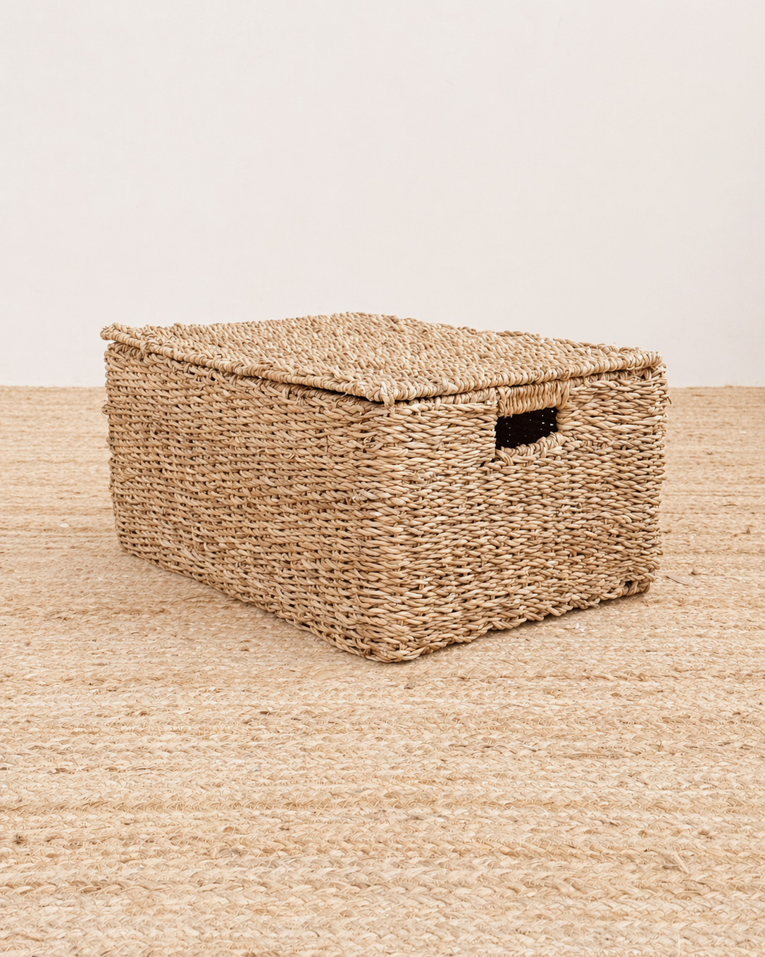 Woven storage basket with a lid on a matching woven surface