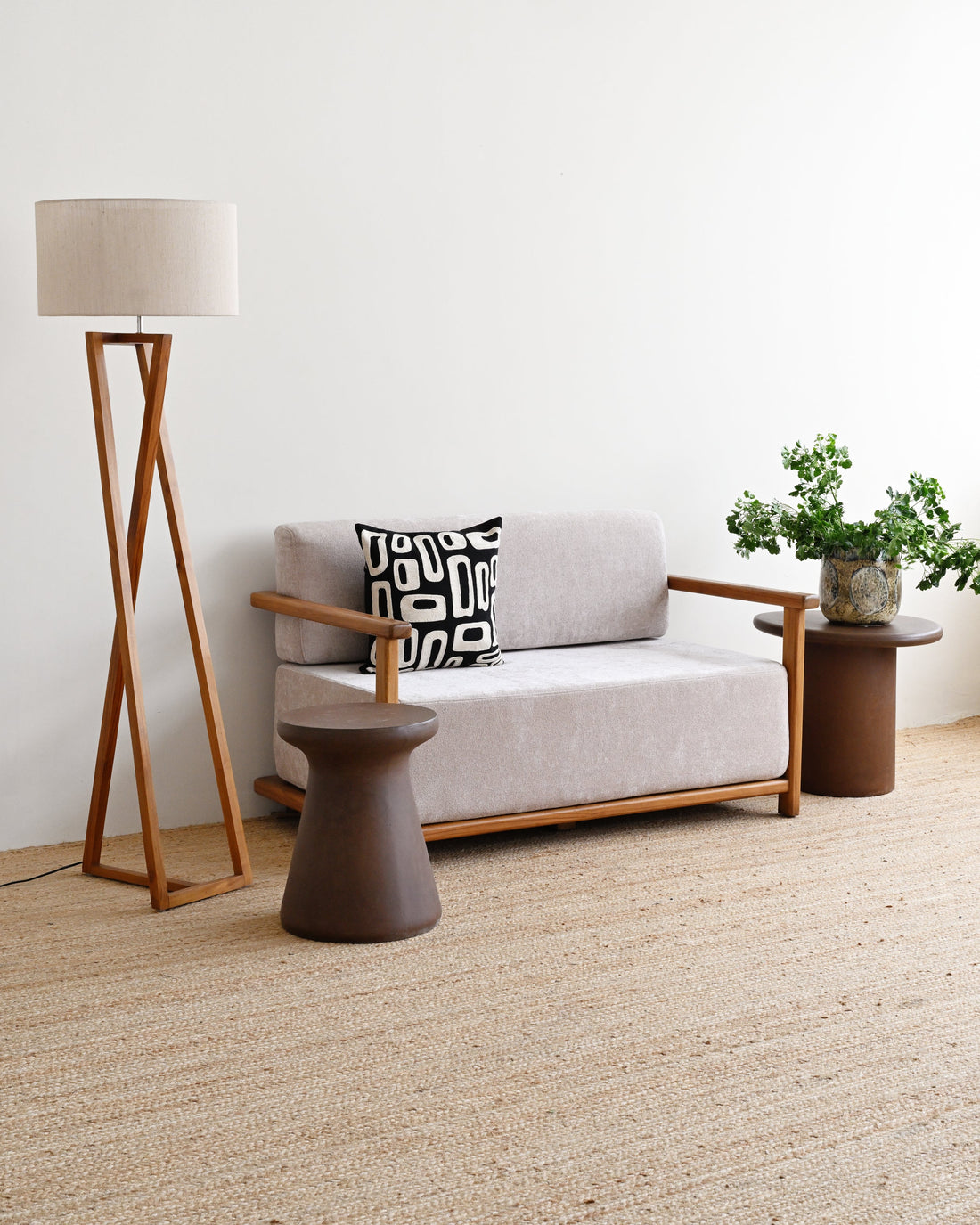 Modern living room with a gray sofa, wooden floor lamp, and side table.