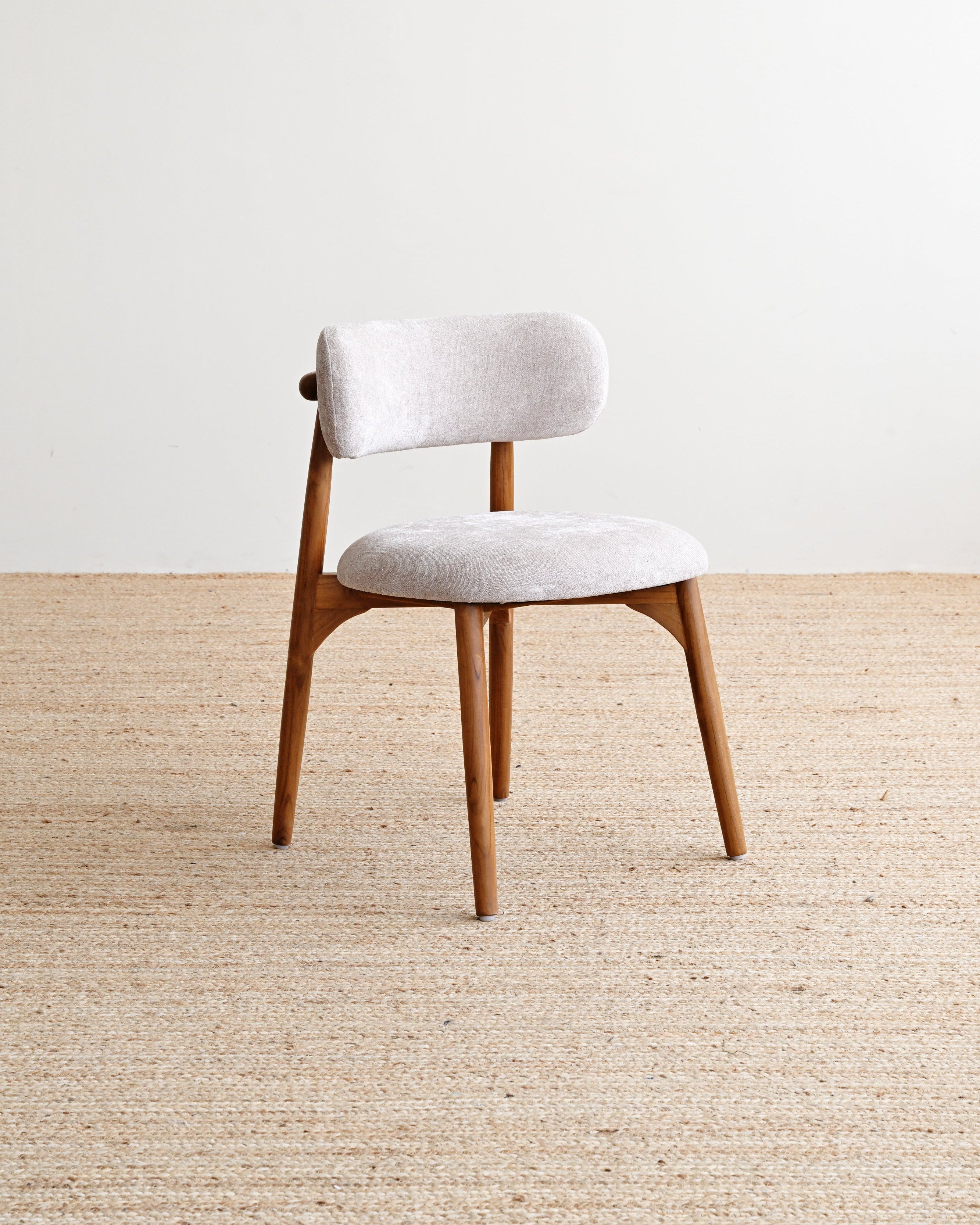 Chair with white cushioned seat and backrest on a beige carpet
