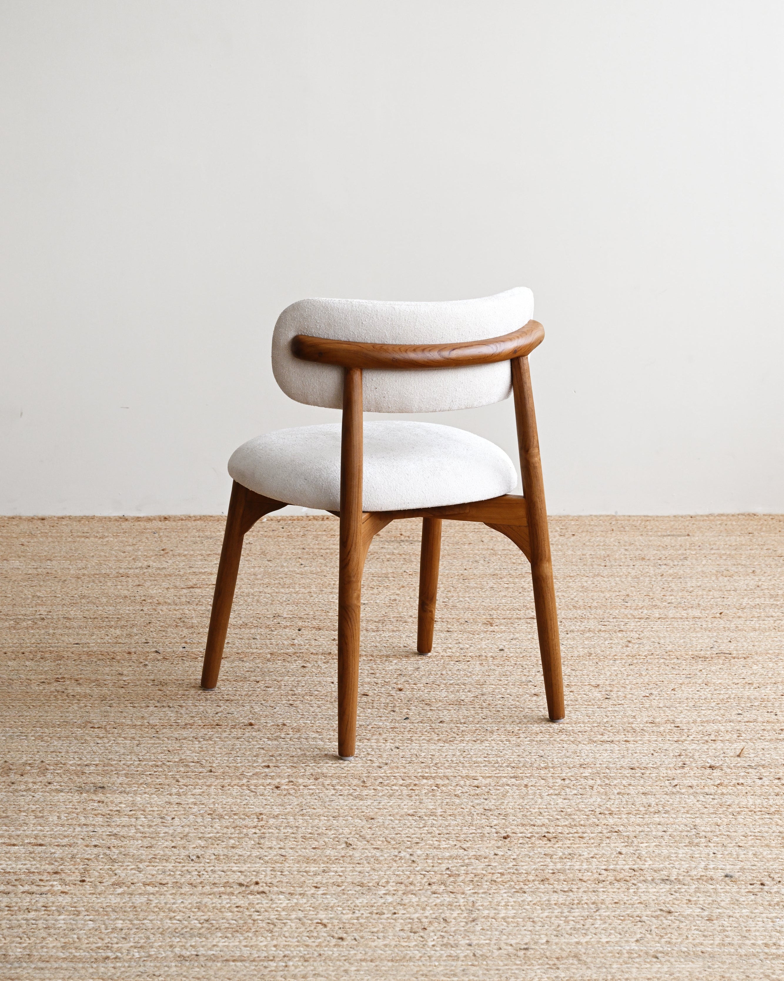 Wooden chair with white cushion on a beige carpet