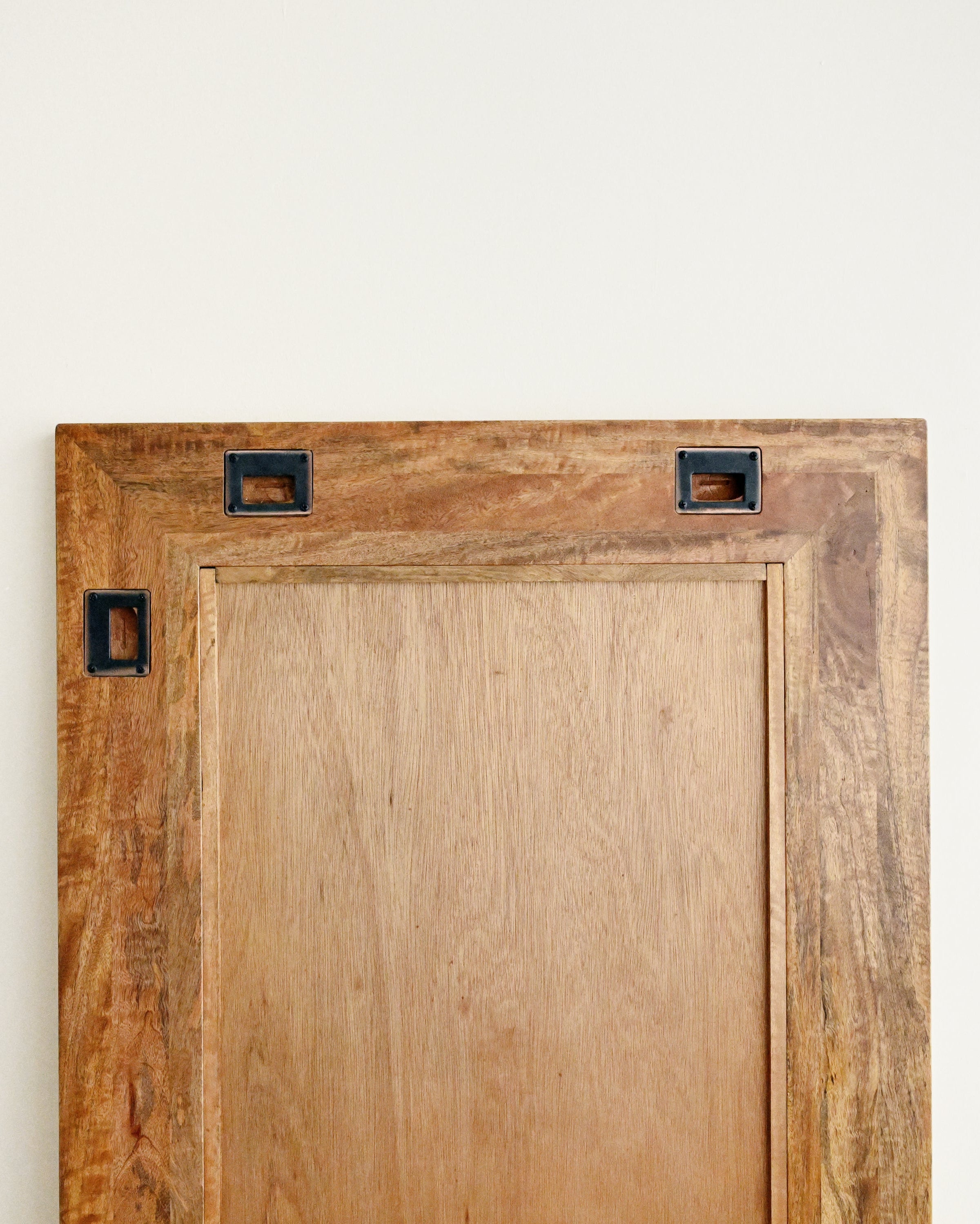 Wooden cabinet door with metal handles on a white background