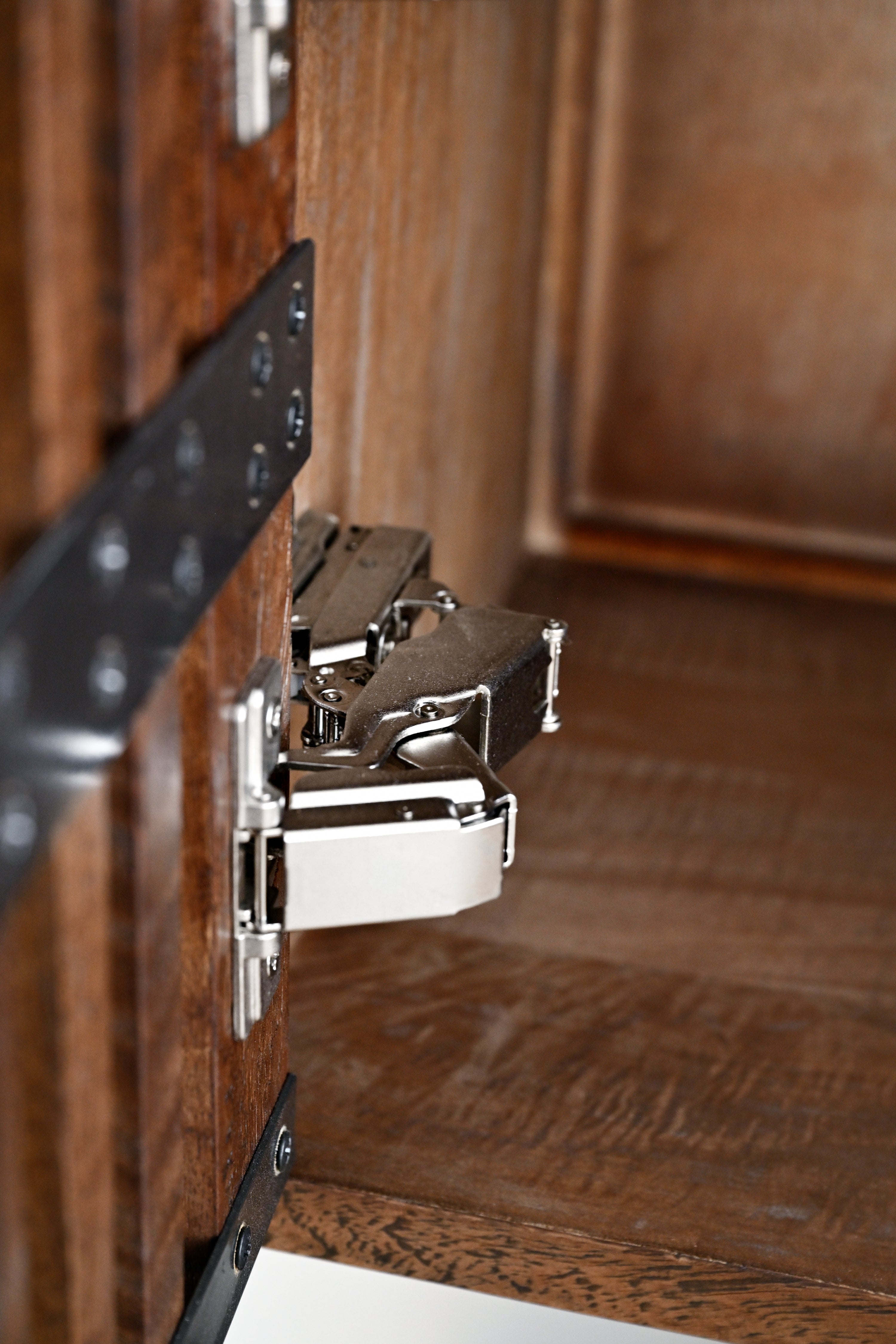 Close-up of a cabinet hinge on wooden furniture