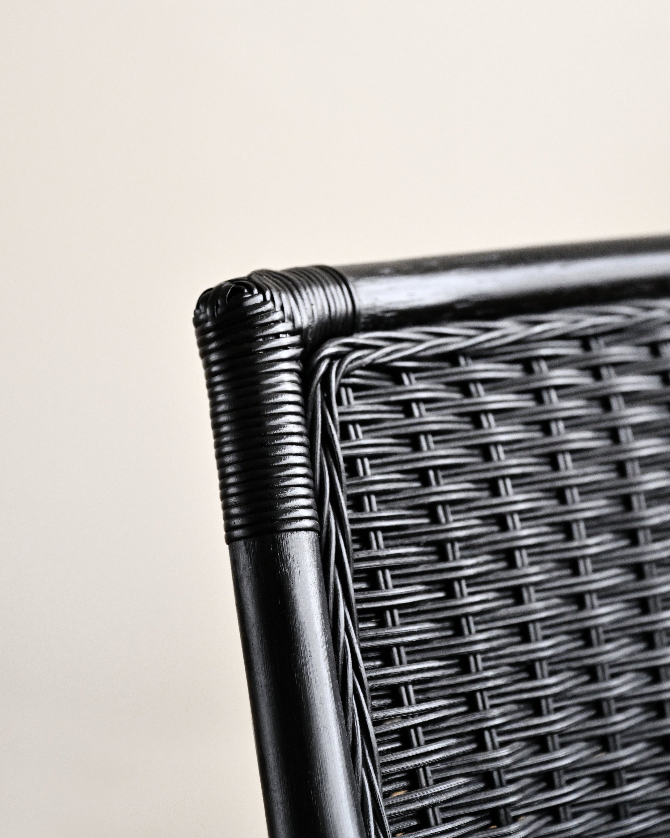 Close-up of a wicker chair armrest on a light background