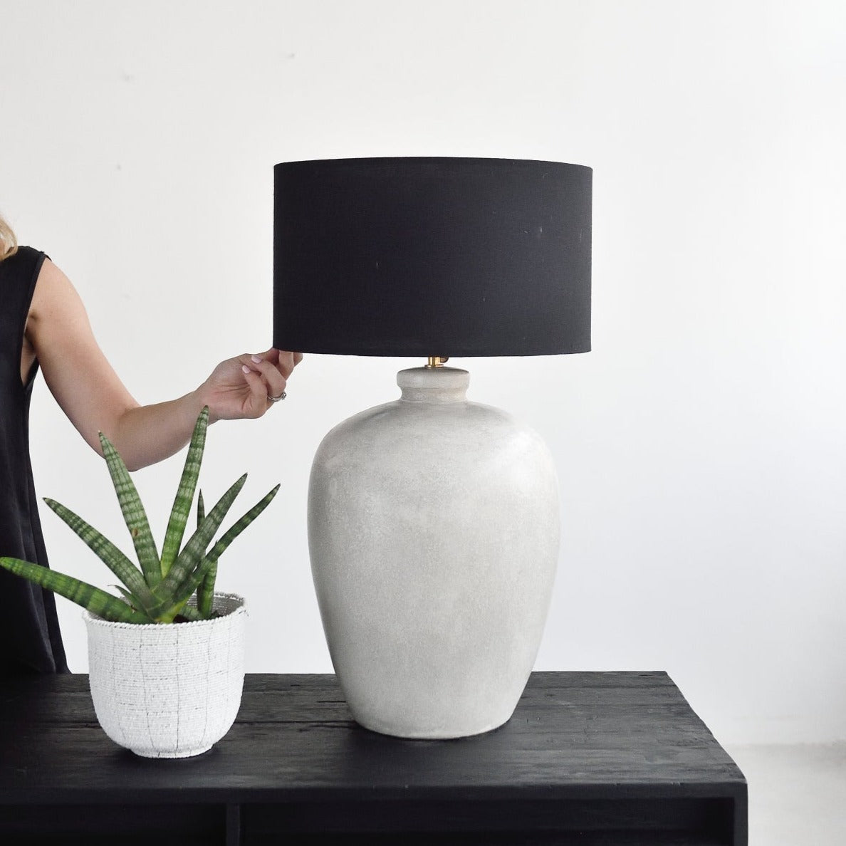 Woman holding stone table lamp by Island Living