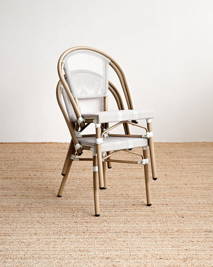 Beige metal chair with white cushion on a beige carpet