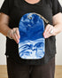 Person holding a blue and white marbled bag against a plain background