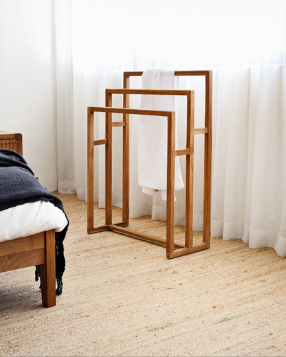Wooden mirrors on a carpeted floor with white curtains in the background