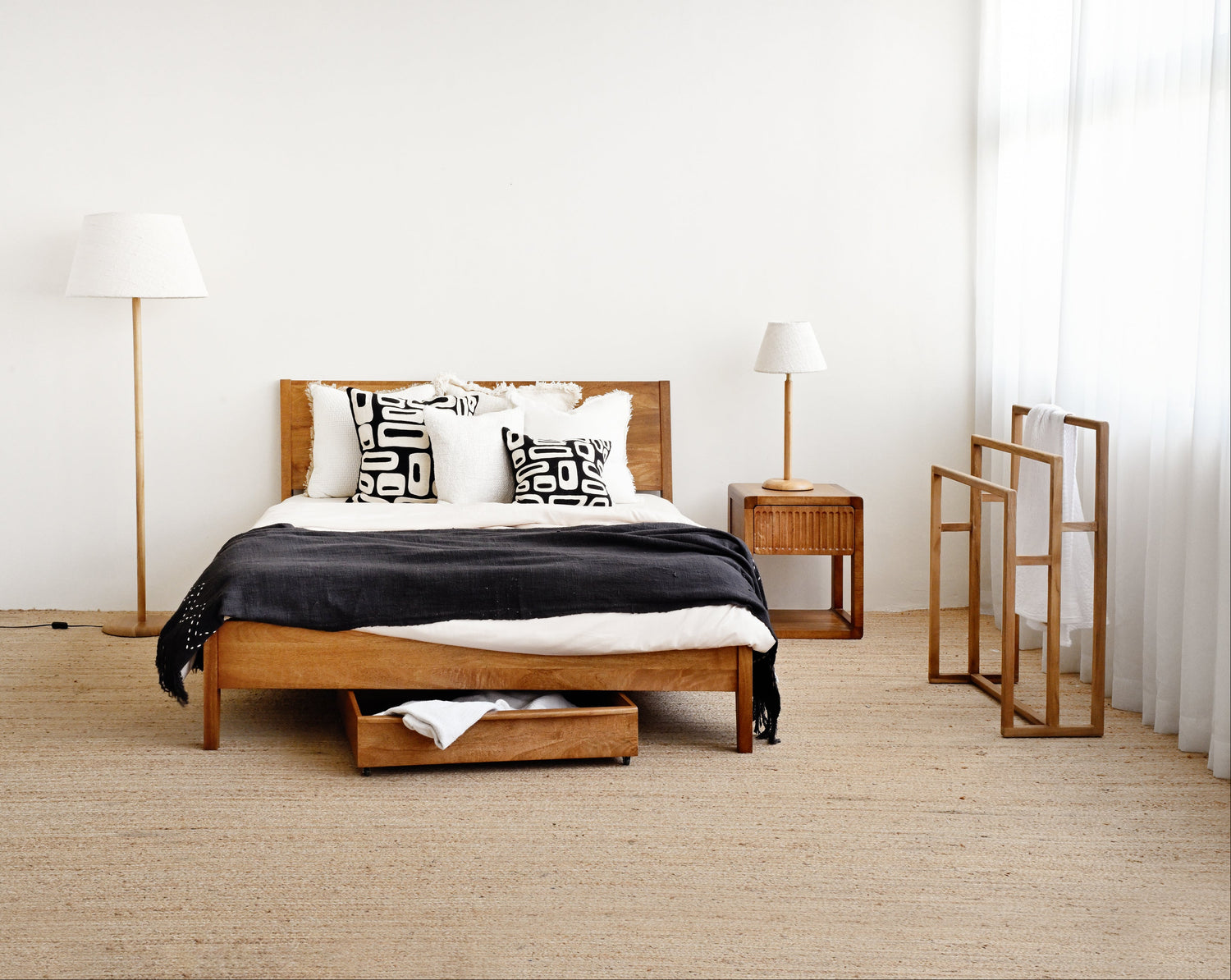 Modern bedroom with wooden bed, nightstands, and lamps.