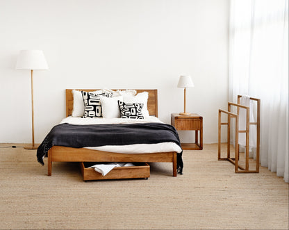 Modern bedroom with wooden bed, nightstands, and lamps.