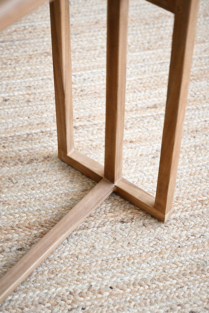 Close-up of a wooden chair frame on a textured beige carpet