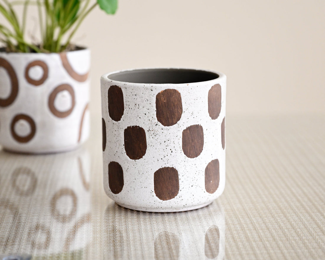 Ceramic planters with brown circular patterns on a neutral background