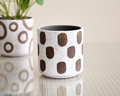 Ceramic planters with brown circular patterns on a neutral background