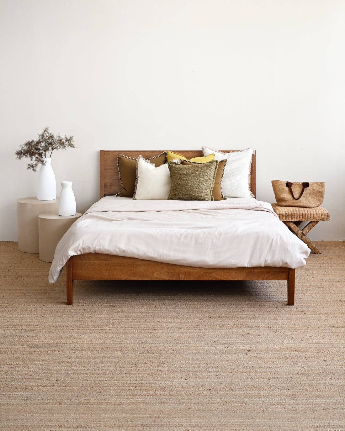 Wooden bed with white bedding in a minimalistic room