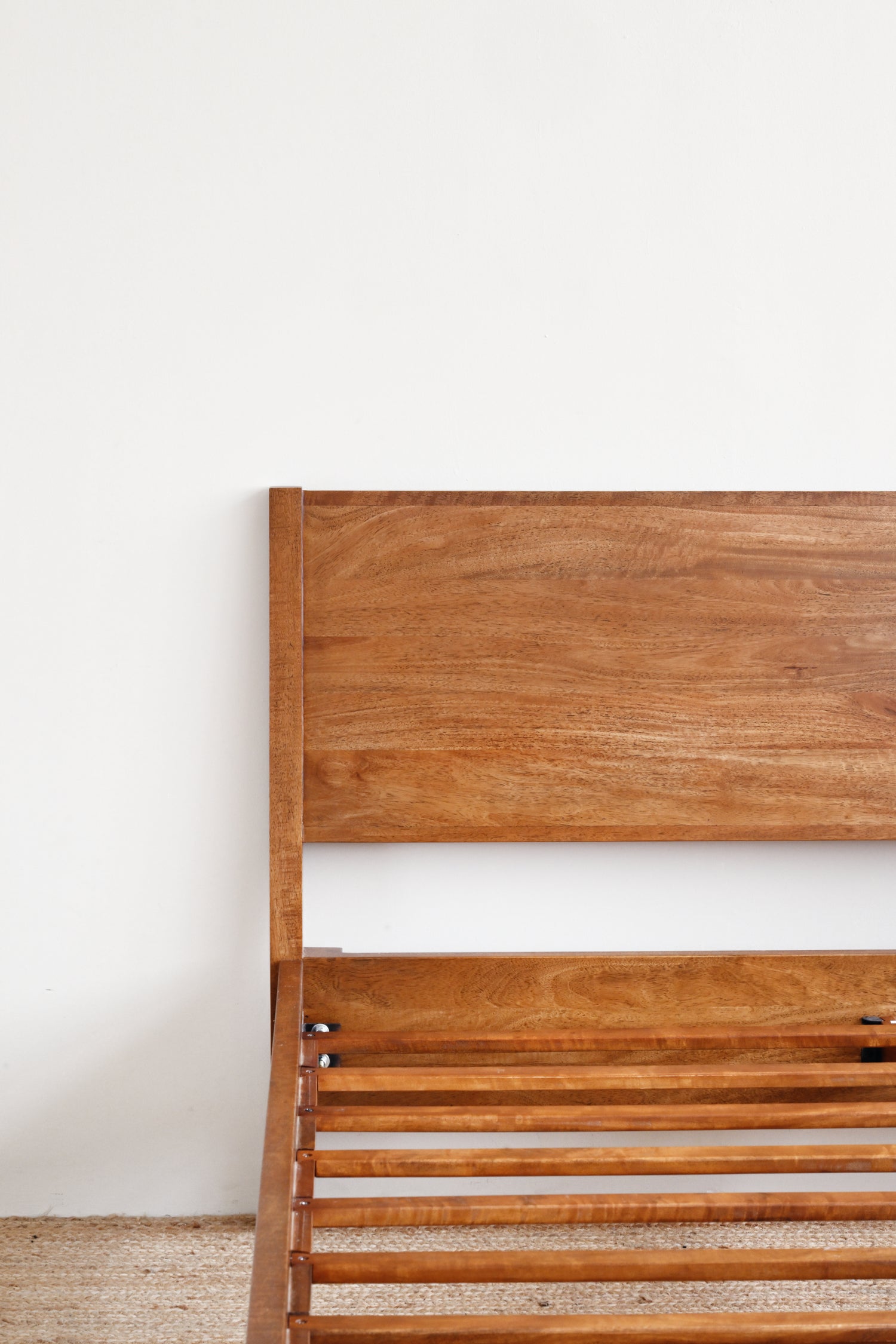 Wooden headboard against a white wall