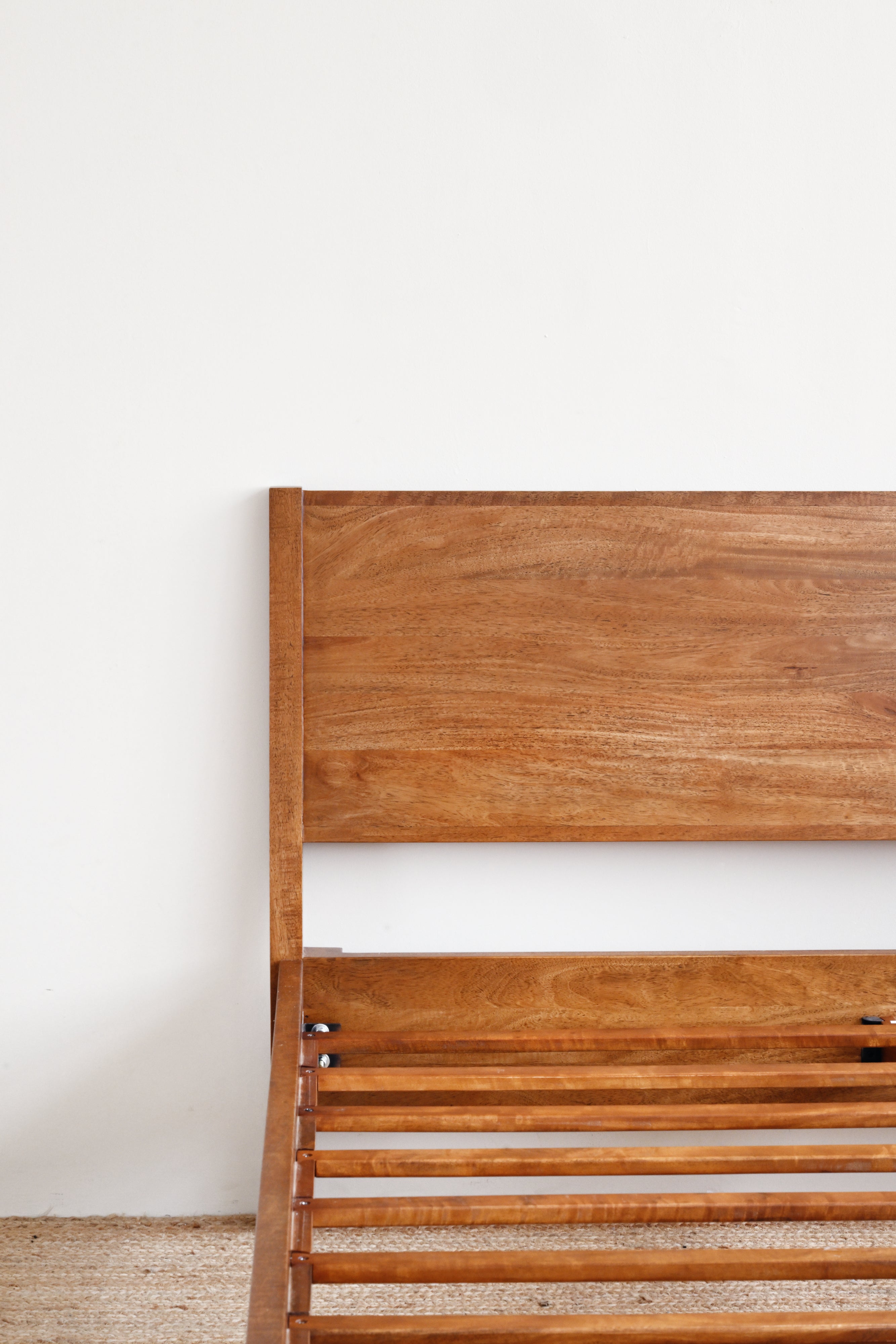 Wooden headboard against a white wall