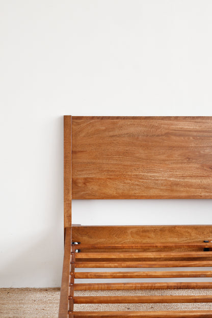 Wooden headboard against a white wall