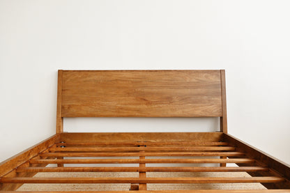 Wooden bed frame against a white wall