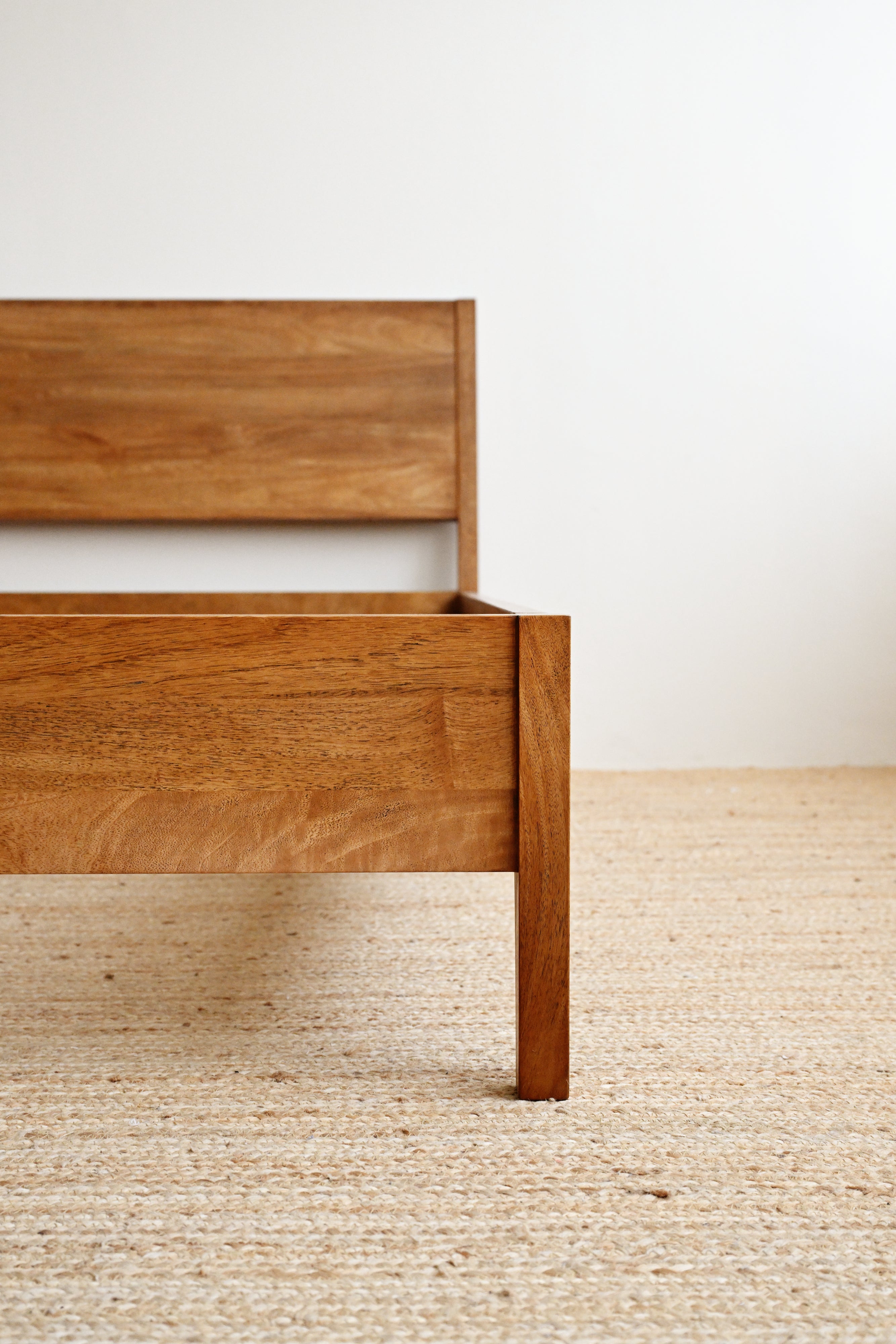 Wooden bed frame on a neutral background