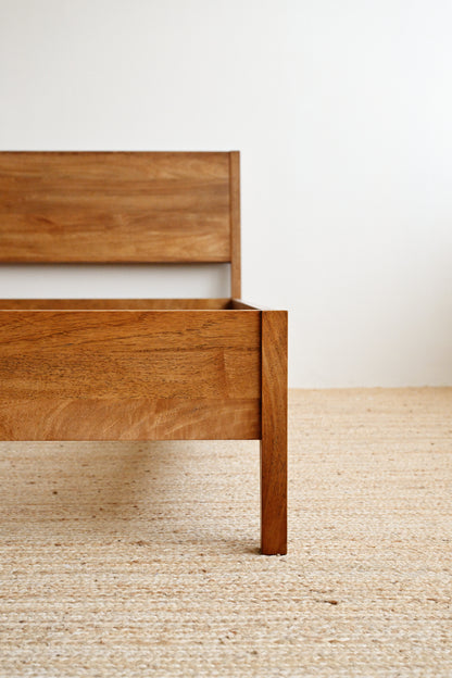 Wooden bed frame on a neutral background