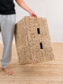 Person holding a woven basket on a wooden floor