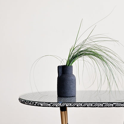 Round marble table with gold legs on a wooden floor against a white wall