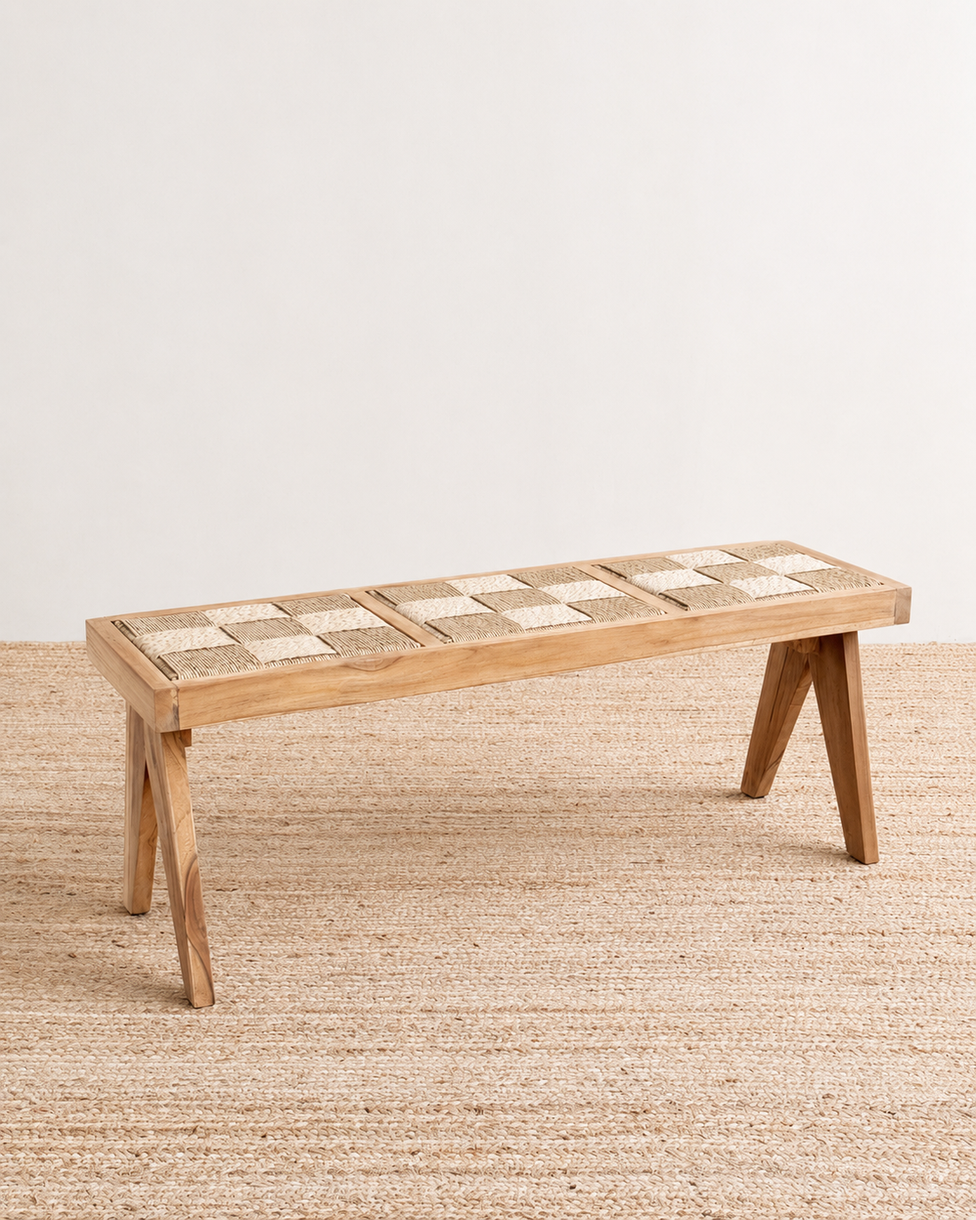 Wooden bench with a woven seat on a beige rug