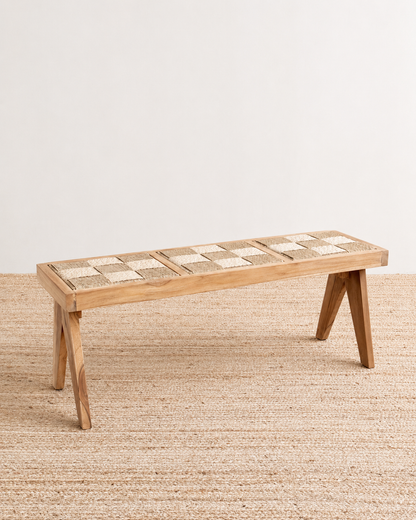 Wooden bench with a woven seat on a beige rug