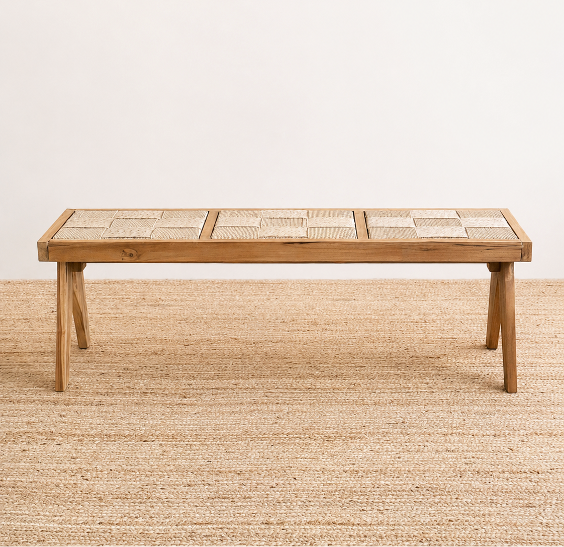 Wooden table on a textured beige floor with a plain white wall background
