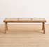 Wooden table on a textured beige floor with a plain white wall background