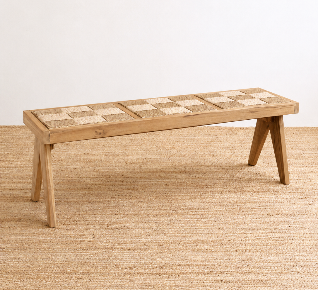 Wooden bench with a checkered top on a textured beige floor.