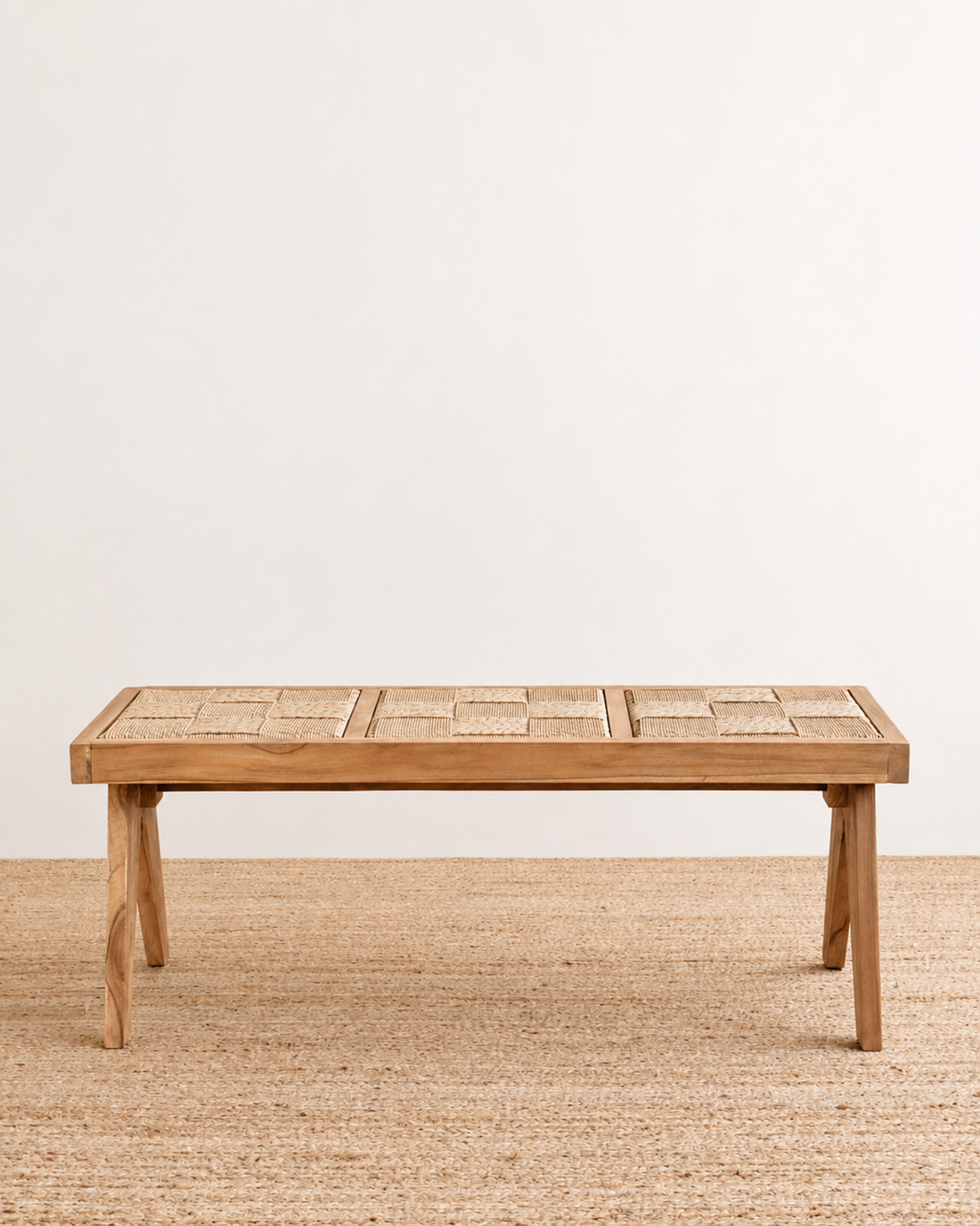 Wooden dining table on a textured floor with a plain background