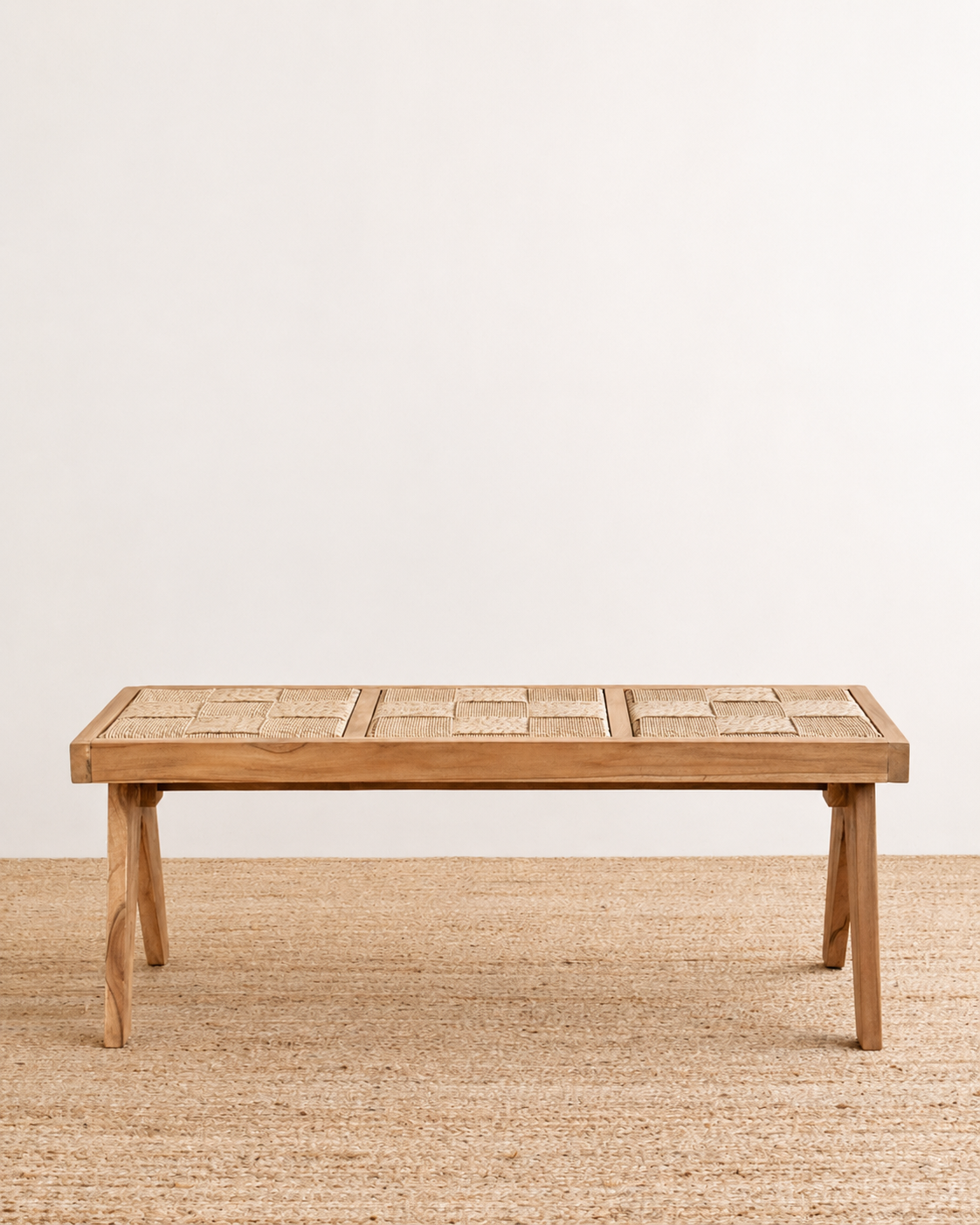 Wooden dining table on a textured floor with a plain background