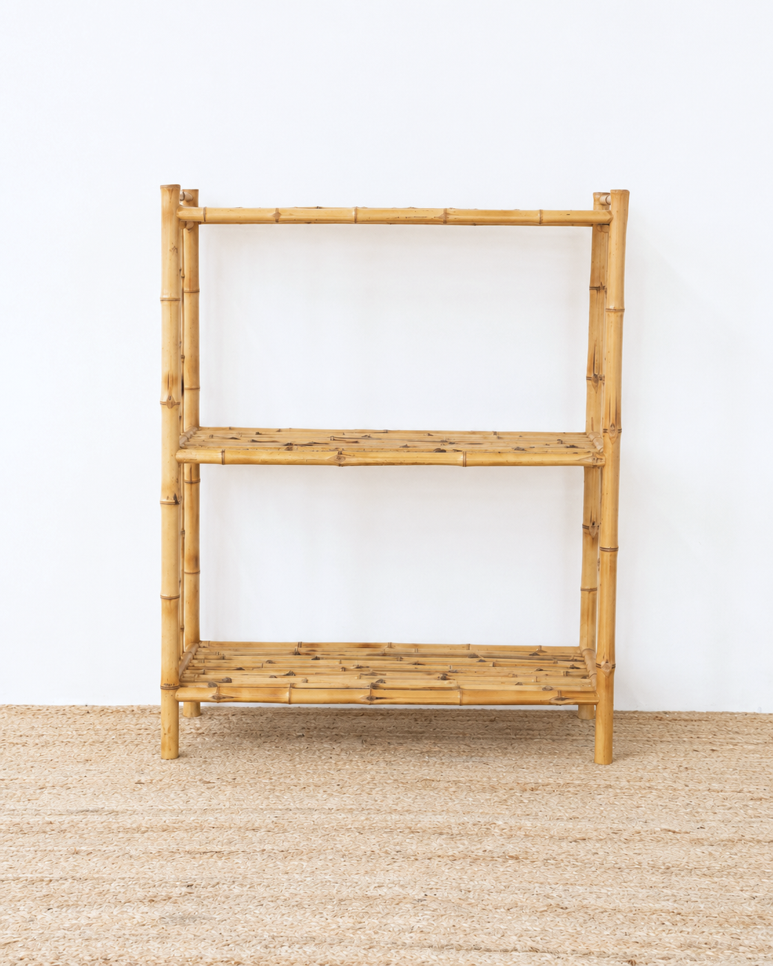 Bamboo shelf against a white wall on a beige carpet
