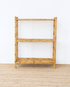 Bamboo shelf against a white wall on a beige carpet