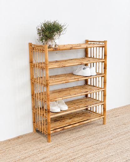 Wooden shoe rack with shoes on a white wall background