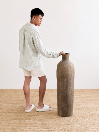 Man holding a large vase in a minimalistic room