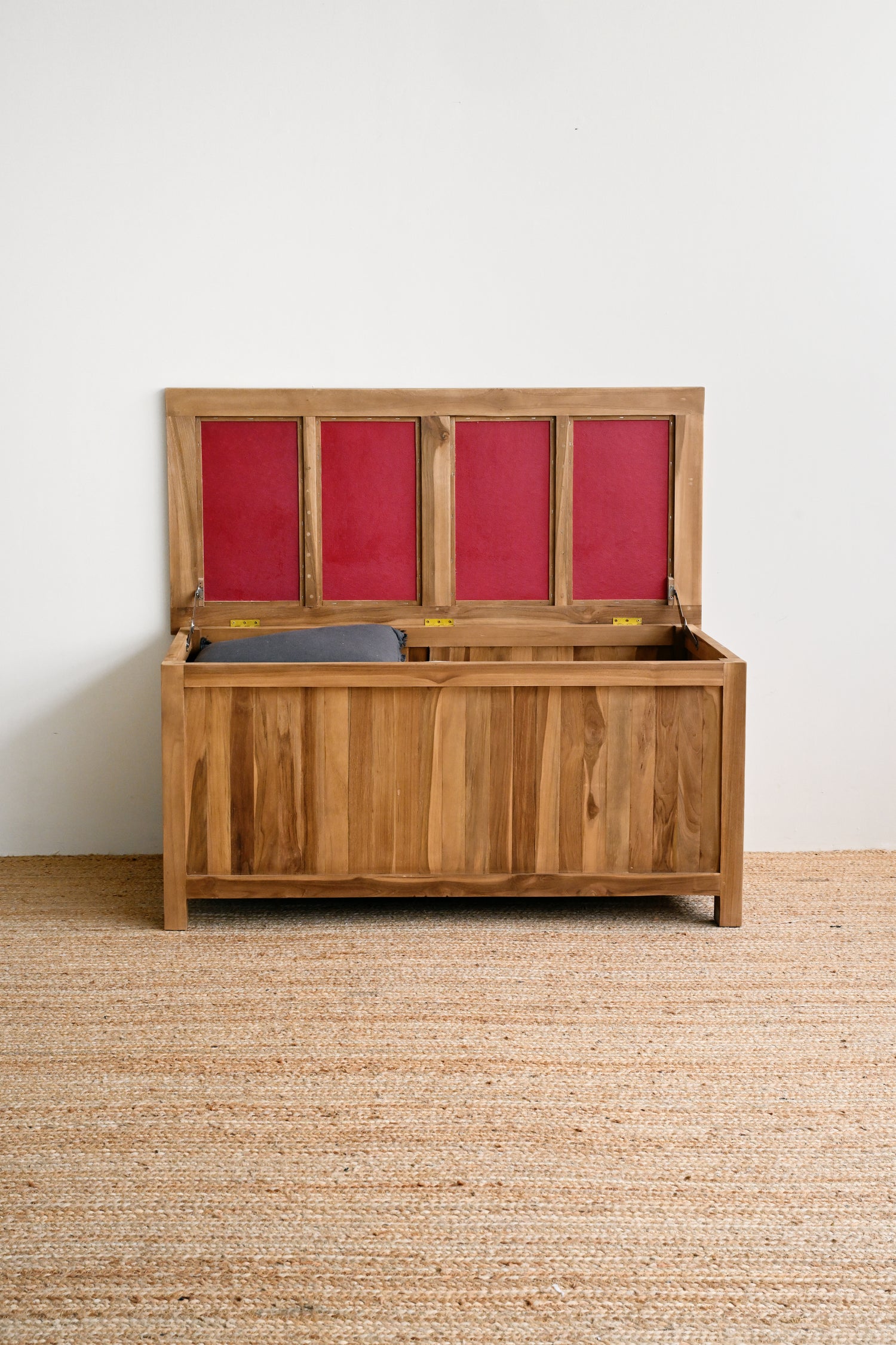 Wooden storage chest with red interior on a beige carpet