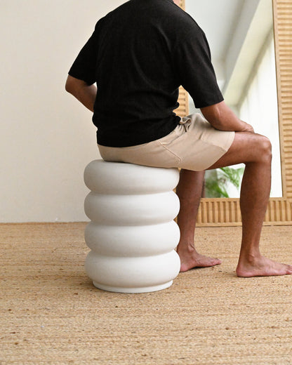 Man sitting on white sculptural stool