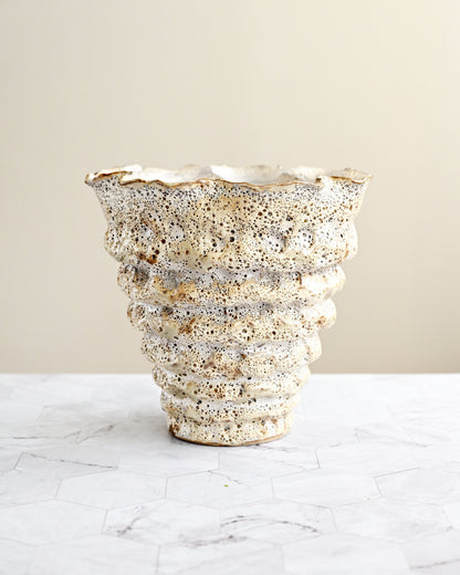 Decorative vase with textured surface on a light background