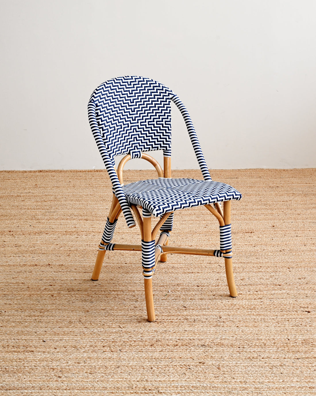 Chair with blue and white patterned seat and backrest on a wooden floor.