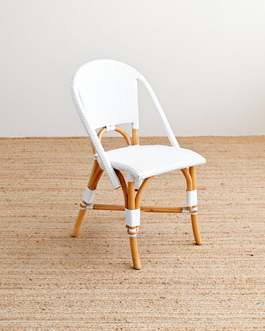 White chair with wooden legs on a beige carpet