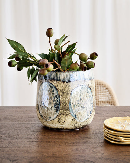 Decorative vase with greenery on a wooden table