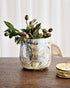 Decorative vase with greenery on a wooden table